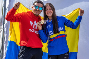 Valentina Roa y Steven Ceballos sostienen la bandera de Colombia