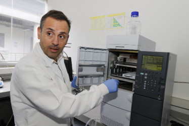 Doctor Carlos Díaz con un cromatógrafo líquido de alta resolución