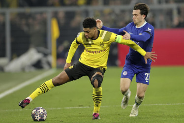 El joven talento inglés Jude Bellingham en el Dortmund (de amarillo) disputa un balón con su compatriota del Chelsea Ben Chilwell.