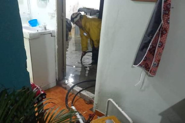 Bomberos sacan el agua que ingresó a una casa por el fuerte aguacero de la noche del miércoles en Anserma. 