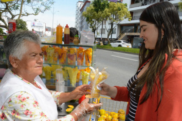 Soralba Cárdenas le vendió a Alexandra Jiménez una porción de frutas para complementar su alimentación.