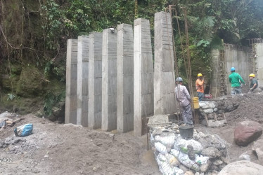 Los obreros trabajan en la construcción de unos muros de contención de empalizadas, en el sitio donde quedaría ubicada la nueva bocatoma de Villamaría (Caldas).