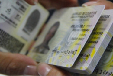 Persona con muchas cédulas de ciudadanía colombianas en las manos.