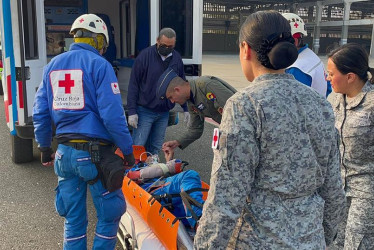 Soldados y miembros de la Cruz Roja mientras atienden a un parapentista luego de su rescate este martes, en Malmabo (Atlántico).