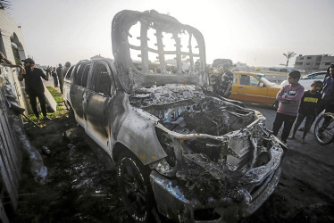 Foto | EFE | LA PATRIA La gente observa el automóvil destruido de la ONG World Central Kitchen (WCK) a lo largo de la carretera Al Rashid, entre Deir Al Balah y Khan Younis, en el sur de la Franja de Gaza.