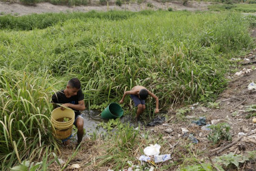 Dos personas recolectan agua de un arroyo, el 27 de marzo, en Guataca, corregimiento de Santa Cruz de Mompox (Bolívar). 