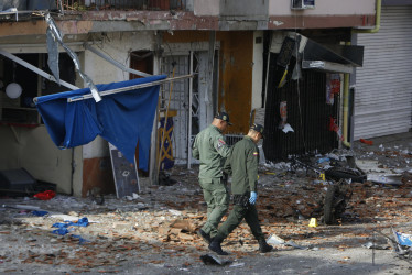 Integrantes de fuerzas de seguridad recorren el lugar donde explotó un artefacto este lunes en Jamundí (Colombia).