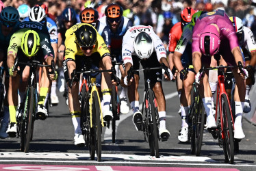 El ciclista holandés Olav Kooij (amarillo) del equipo Visma Lease a Bike se acerca a la línea de meta para ganar la novena etapa de la 107.ª carrera ciclista Giro de Italia de 2024, a lo largo de 214 km desde Avezzano a Nápoles, Italia, el 12 de mayo de 2024.