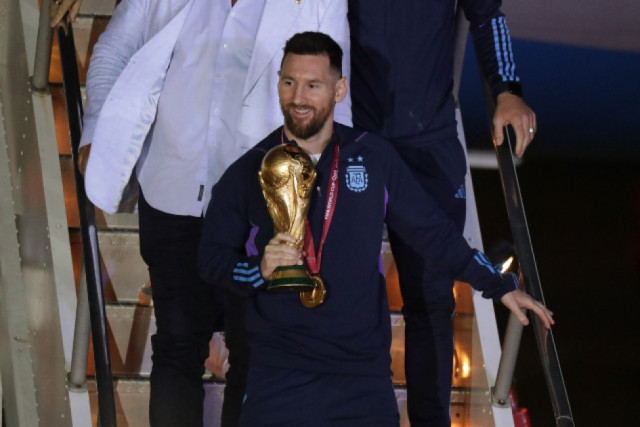 Lionel Messi, mientras bajaba del avión en la madrugada de ayer con la Copa del Mundo al frente de la delegación de Argentina.