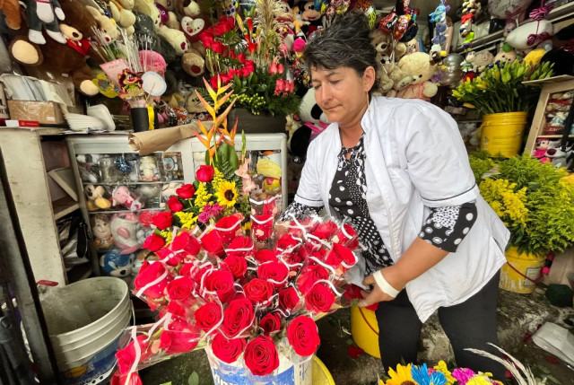 Luz Dary Mejía prepara en su puesto de trabajo las flores para vender en esta fecha. Ella es madre de Laura y Ana María. 