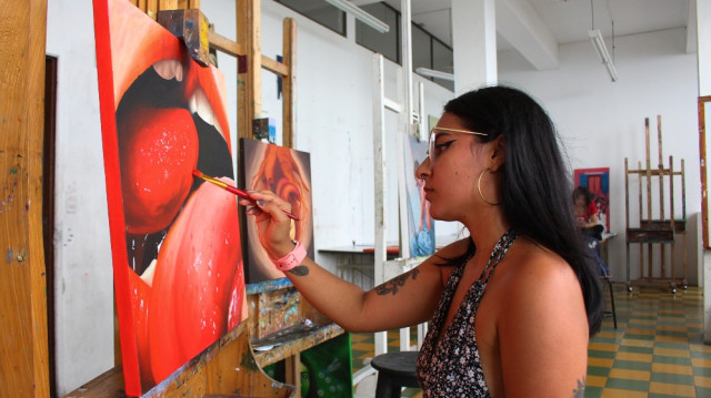La pasión de Andrea Villa es pintar la figura femenina y su técnica favorita es el realismo. Por ahora está experimentando con el color rojo.