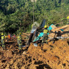 Rescatistas y policías trabajan en la recuperación de cuerpos en el lugar donde ocurrió un derrumbe en inmediaciones del municipio de El Carmen de Atrato (Chocó).