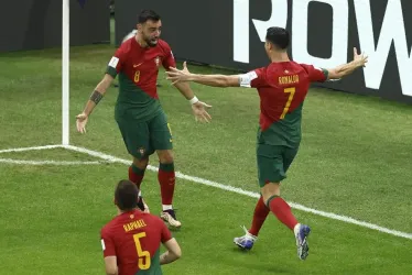 Cristiano Ronaldo (d) y Bruno Fernandes (i) de Portugal celebran un gol hoy, en un partido de la fase de grupos del Mundial de Fútbol Qatar 2022 entre Portugal y Uruguay en el estadio Lusail en la ciudad de Lusail, (Catar).