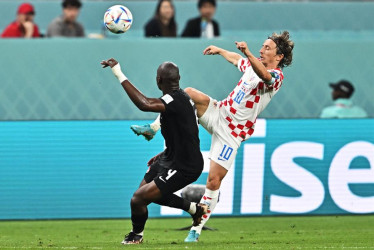 Luka Modric (derecha) disputa un balón contra el canadiense Kamal Miller.