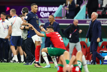 Kylian Mbappé (izquierda) levanta a su amigo marroquí Achraf Hakimi, derrumbado tras perder ante Francia la semifinal de la Copa del Mundo.