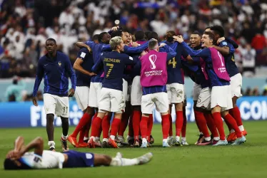 Los jugadores de Francia celebran mientras Jude Bellingham de Inglaterra reacciona en el suelo después del partido de fútbol de cuartos de final de la Copa Mundial de la FIFA 2022 entre Inglaterra y Francia en el estadio Al Bayt en Al Khor, Qatar.