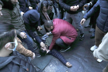 Un hombre recibe ayuda cuando los manifestantes y los policías franceses se enfrentan después de la conferencia de prensa del ministro Gerald Darmanin luego de un tiroteo cerca de un centro cultural kurdo en París.