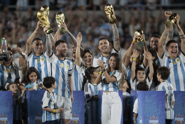 Lionel Messi (adelante, a la izquierda), acompañado de su esposa Antonela Roccuzzo y sus hijos, encabezó la celebración argentina, en la que los jugadores levantaron el trofeo de la Copa Mundo ante su hinchada, en la primera presentación de la Selección como tricampeona tras la obtención del título en Qatar 2022.