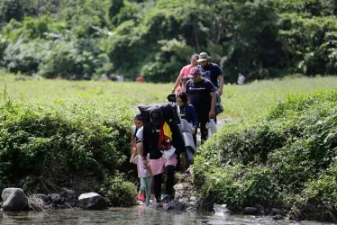 Una familia de migrantes camina en el sector de Cañas Blancas en el Darién (Panamá). Una media de 2.500 migrantes llegan cada día a Panamá en su viaje hacia Norteamérica tras cruzar la inhóspita jungla del Darién, en la frontera con Colombia.