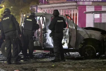 Policías investigan los restos de un carro bomba que explotó en la madrugada del jueves en los exteriores del edificio del Servicio Nacional de Atención Integral a Personas Privadas de Libertad (SNAI), en Quito (Ecuador).