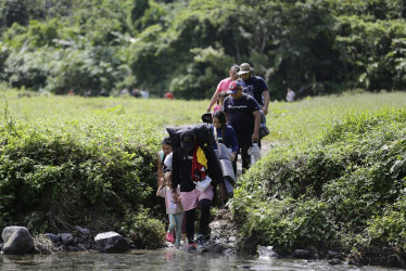 Unos migrantes acompañados con niños pequeños caminan en el sector de Cañas Blancas en Darién (Panamá), en agosto del 2023. 