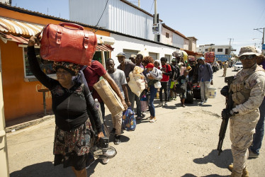 Foto / EFE / LA PATRIA  Ciudadanos haitianos cargan sus pertenencias para abandonar el país.