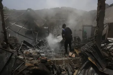Un hombre usa un extintor en los escombros de una vivienda destruida por un ataque con carro bomba que iba dirigido a una estación policial en la localidad de Timba, Cauca. El ataque con explosivos fue perpetrado en la mañana del miércoles. 