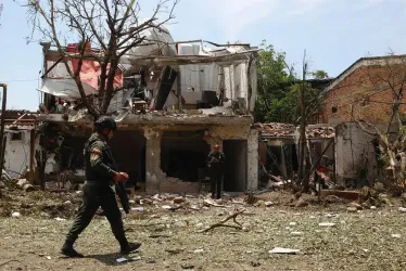 Un policía camina cerca de una vivienda destruida por un carro bomba, activado contra una subestación de policía este viernes, en el corregimiento Potrerito de Jamundí, Valle del Cauca. Al menos cinco personas resultaron heridas.