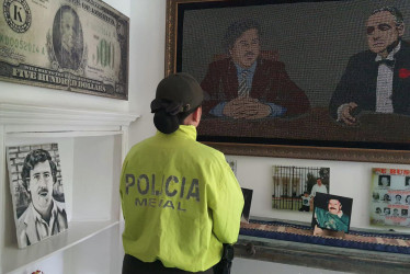Fotografía cedida por la Fiscalía General de la Nación donde se ve a una policía observando objetos que hacen parte de un museo privado del narcotraficante Pablo Escobar, en Medellín.