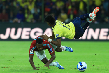 El colombiano Jhon Arias cae al suelo tras disputar un balón con el ecuatoriano Kevin Rodríguez. Los cafeteros se salvaron de los goles de la 'Tri' por dos disparos al palo, derrocharon un cobro desde el punto penal y marcaron dos tantos que fueron invalidados.