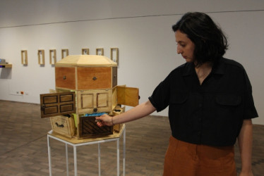 La artista Érika Orozco Lozano con uno de los retratos de cajón que hacen parte de la exposición.