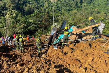 Rescatistas y policías trabajan en la recuperación de cuerpos en el lugar donde ocurrió un derrumbe en inmediaciones del municipio de El Carmen de Atrato (Chocó).