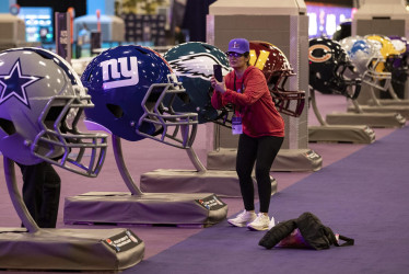 Una mujer toma una fotografía de cascos de fútbol de gran tamaño en la experiencia del Super Bowl en el Centro de Convenciones Mandalay Bay South en Las Vegas, Nevada, EE.UU.