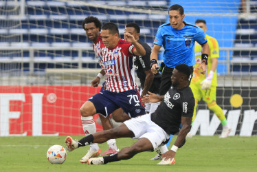 Carlos Bacca (i) disputa el balón con Bastos este martes, en un partido de la fase de grupos de la Copa Libertadores entre Junior y Botafogo en el estadio Metropolitano en Barranquilla.