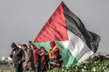 Varios palestinos portan una bandera.