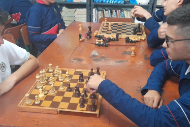 Unos 30 estudiantes se reúnen en la biblioteca para jugar ajedrez. 